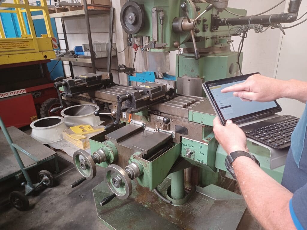 Monteur wijst op tablet machine onderhoud Service en Reviesie Velmon